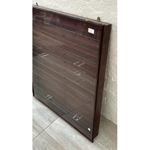 34 - A mahogany effect wall hanging model display cabinet with eleven glass shelves - approx. 86cm high x... 