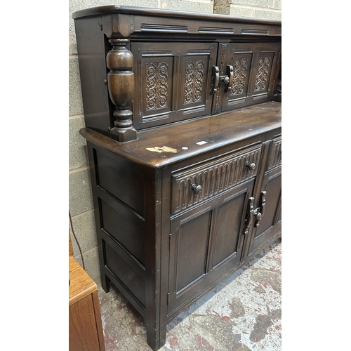 41A - An Ercol Old Colonial elm and beech court cupboard - approx. 131cm high x 130cm wide x 49cm deep