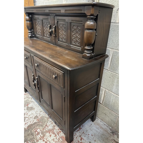 41A - An Ercol Old Colonial elm and beech court cupboard - approx. 131cm high x 130cm wide x 49cm deep