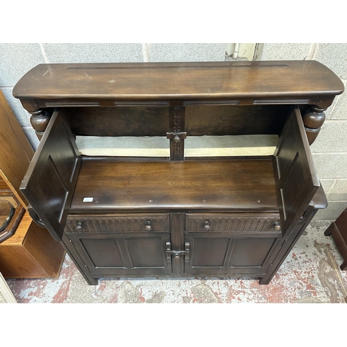 41A - An Ercol Old Colonial elm and beech court cupboard - approx. 131cm high x 130cm wide x 49cm deep