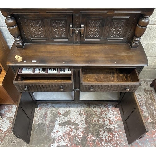 41A - An Ercol Old Colonial elm and beech court cupboard - approx. 131cm high x 130cm wide x 49cm deep