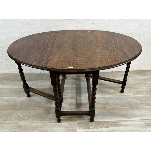 48A - An oak drop leaf gate leg barley twist dining table - approx. 71cm high x 105cm wide x 135cm long