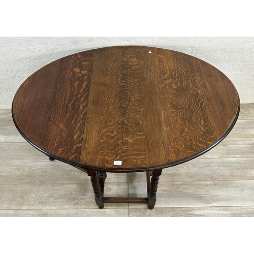 48A - An oak drop leaf gate leg barley twist dining table - approx. 71cm high x 105cm wide x 135cm long