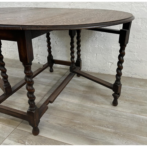 48A - An oak drop leaf gate leg barley twist dining table - approx. 71cm high x 105cm wide x 135cm long