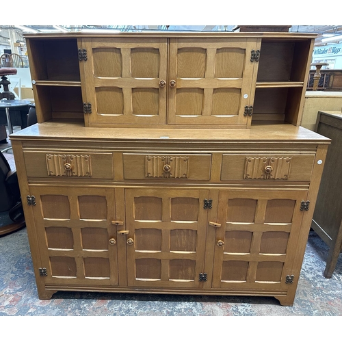 55 - A carved oak court cupboard - approx. 135cm high x 138cm wide x 46cm deep