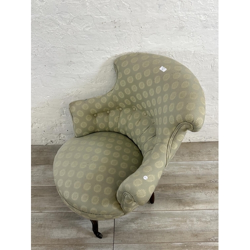 65 - A Victorian button back fabric upholstered armchair on mahogany supports and castors