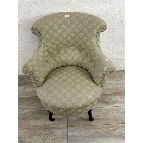 65 - A Victorian button back fabric upholstered armchair on mahogany supports and castors