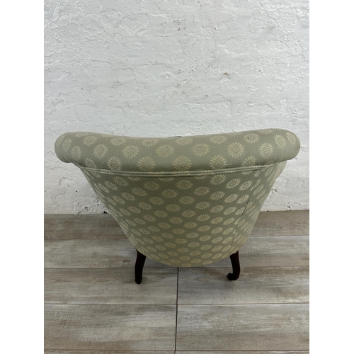 65 - A Victorian button back fabric upholstered armchair on mahogany supports and castors