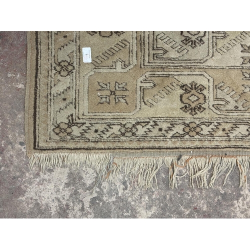 7 - A mid/late 20th century machine woven tasselled rug - approx. 200cm x 120cm