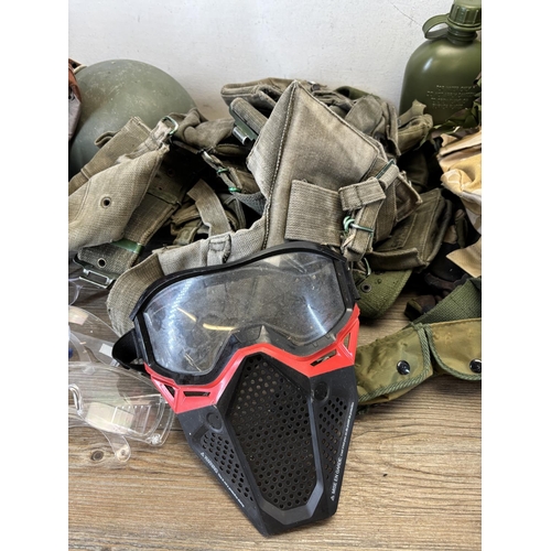 410 - A collection of military and paintballing clothing and accessories to include green canvas ammunitio... 