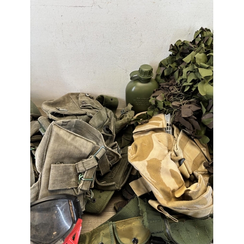 410 - A collection of military and paintballing clothing and accessories to include green canvas ammunitio... 