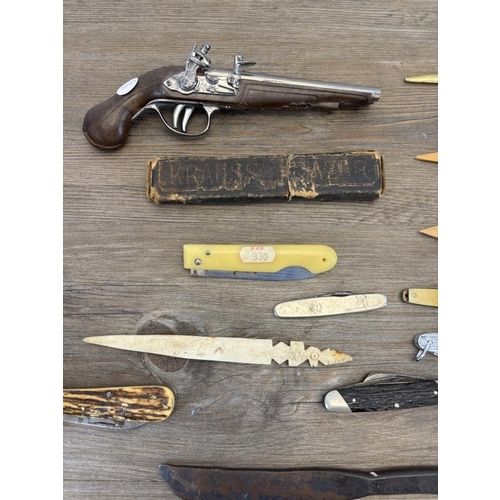 432 - A collection of items to include replica flintlock pistol, various pocket knives, cut throat razors ... 