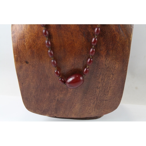 2110 - A cherry Bakelite beaded necklace with internal streaking - approx. gross weight 23.6g