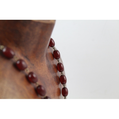 2110 - A cherry Bakelite beaded necklace with internal streaking - approx. gross weight 23.6g