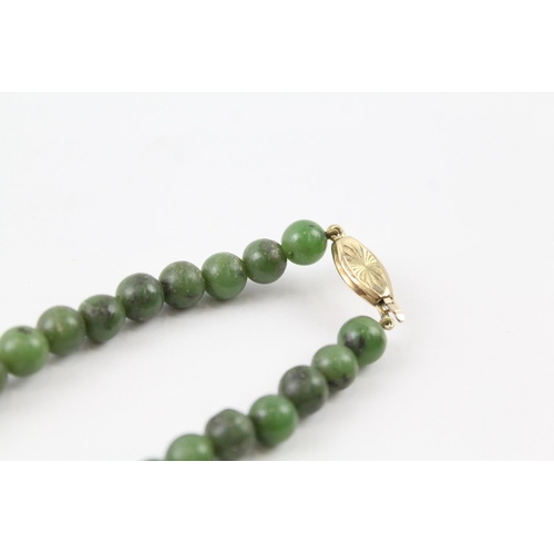 2055 - A nephrite beaded necklace with 9ct gold clasp - approx. gross weight 40.3g