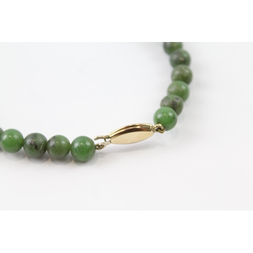 2055 - A nephrite beaded necklace with 9ct gold clasp - approx. gross weight 40.3g