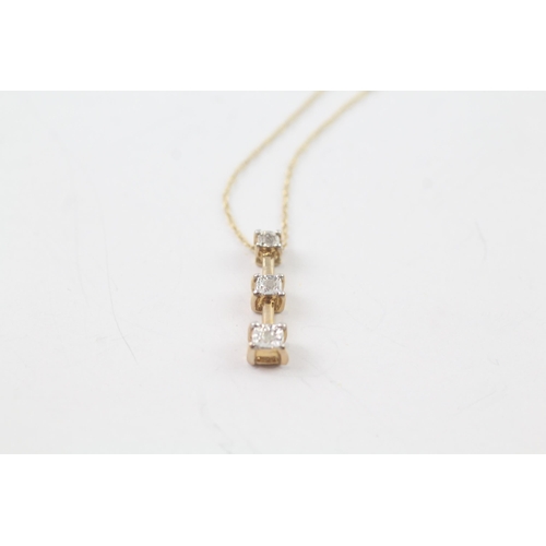 2058 - A 9ct gold graduated diamond pendant necklace - approx. gross weight 1.1g