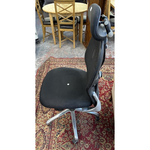 1147 - A modern black plastic and meshed fabric swivel office desk chair