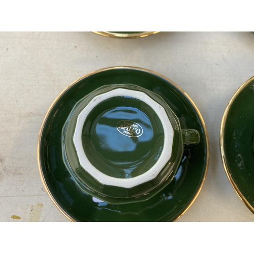 1278 - Twenty Apilco of France green and gold ceramic cups and saucers