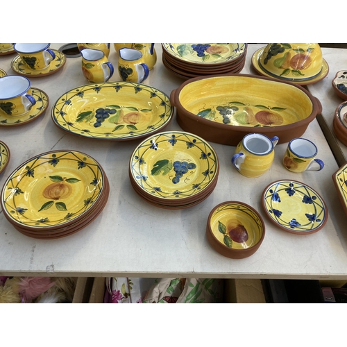 1296 - Sixty one pieces of Portuguese hand painted glazed terracotta pottery