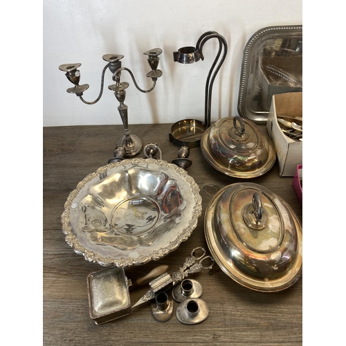 1324 - A collection of silver plated ware to include cutlery, tureens, circular footed dish etc.