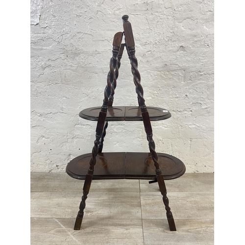 1131 - An early 20th century oak barley twist two tier folding cake stand - approx. 86cm high