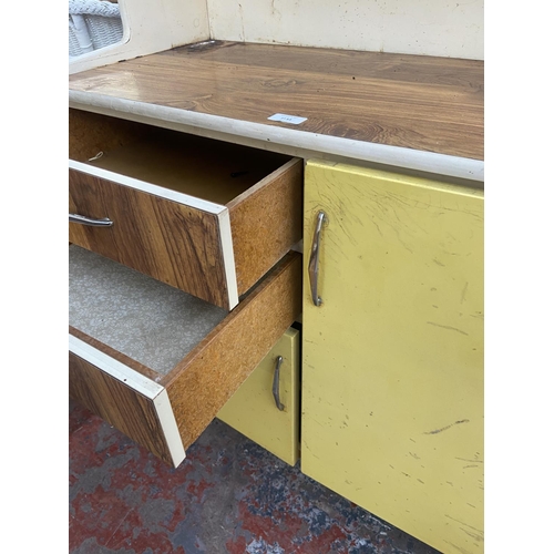 1133 - A mid 20th century Fortress yellow and white painted and teak effect kitchen cabinet - approx. 149cm... 