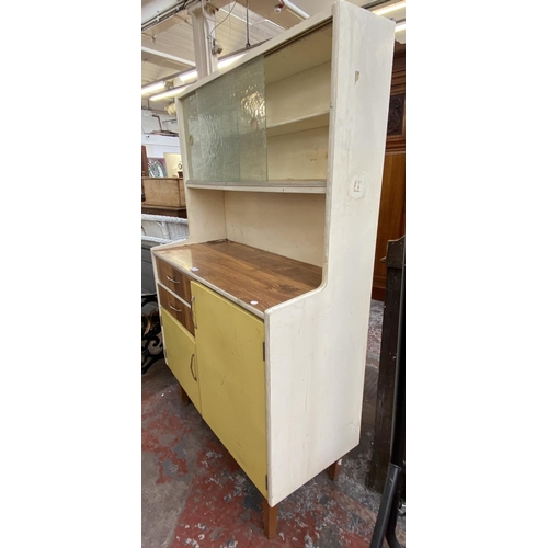 1133 - A mid 20th century Fortress yellow and white painted and teak effect kitchen cabinet - approx. 149cm... 