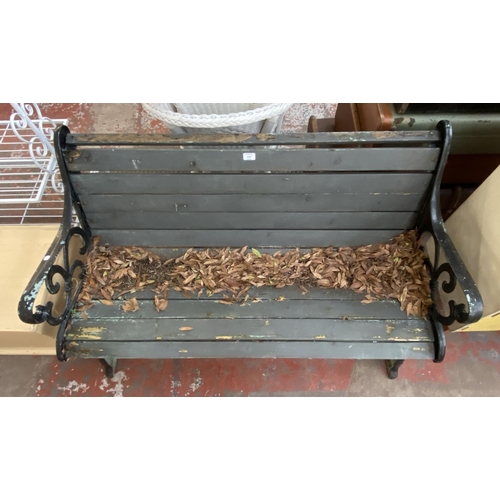 1134 - A cast iron and wooden slatted garden bench - approx. 77cm high x 126cm wide x 60cm deep