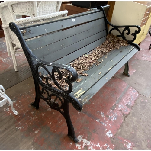 1134 - A cast iron and wooden slatted garden bench - approx. 77cm high x 126cm wide x 60cm deep