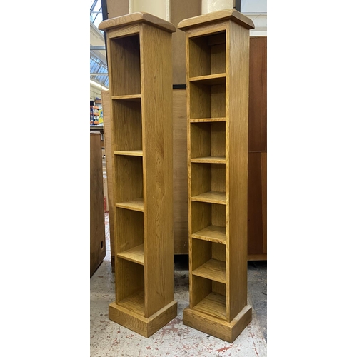 1163 - Two modern oak CD racks - approx. 116cm high x 22cm wide x 18cm deep