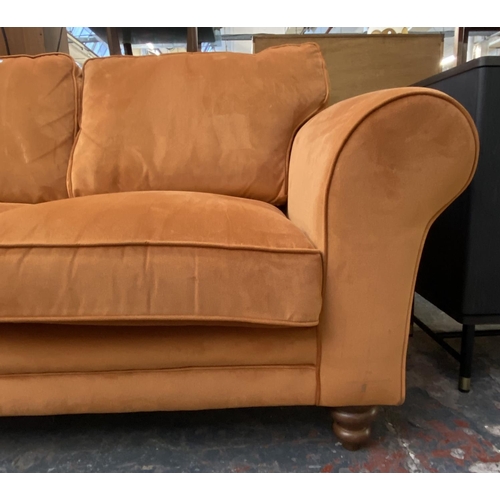 1164 - A modern orange fabric upholstered two seater sofa on turned wood supports - approx. 72cm high x 180... 