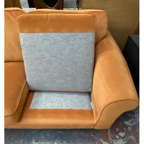 1164 - A modern orange fabric upholstered two seater sofa on turned wood supports - approx. 72cm high x 180... 