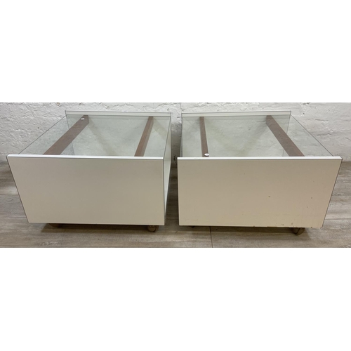 1168 - A pair of mid 20th century white laminate and glass top side tables - approx. 40cm high x 62cm wide ... 