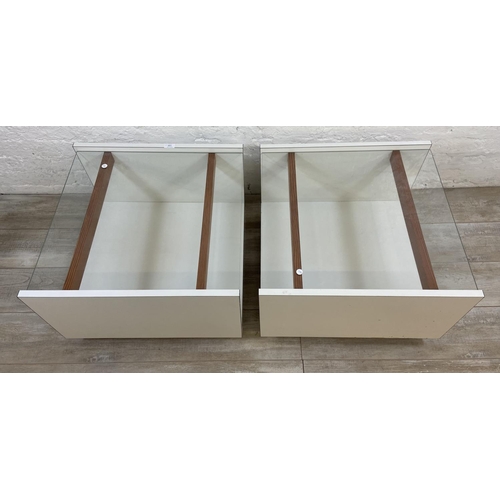 1168 - A pair of mid 20th century white laminate and glass top side tables - approx. 40cm high x 62cm wide ... 