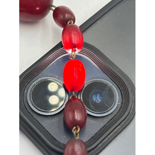 2110 - A cherry Bakelite beaded necklace with internal streaking - approx. gross weight 23.6g