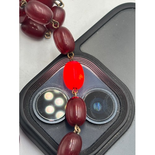 2110 - A cherry Bakelite beaded necklace with internal streaking - approx. gross weight 23.6g