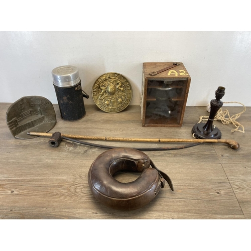 1409 - A collection of items to include leather horse shoe boil boot, Bakelite table lamp, cased gas mask, ... 