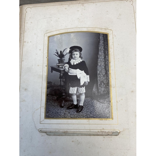 1415 - A Victorian leather bound carte de visite album with metal clasp containing sixty nine photographs