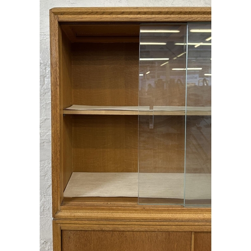 1184 - A mid 20th century oak bookcase with two glass sliding doors - approx. 122cm high x 76cm wide x 26cm... 