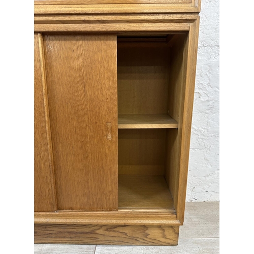 1184 - A mid 20th century oak bookcase with two glass sliding doors - approx. 122cm high x 76cm wide x 26cm... 