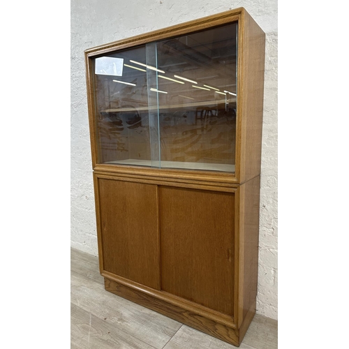 1184 - A mid 20th century oak bookcase with two glass sliding doors - approx. 122cm high x 76cm wide x 26cm... 