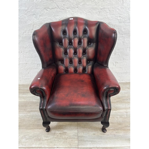 1187 - An oxblood leather Chesterfield wingback armchair - approx. 104cm high x 80cm wide x 75cm deep