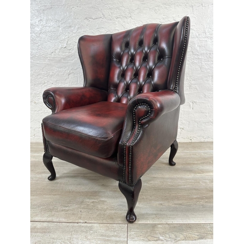 1187 - An oxblood leather Chesterfield wingback armchair - approx. 104cm high x 80cm wide x 75cm deep