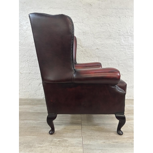 1187 - An oxblood leather Chesterfield wingback armchair - approx. 104cm high x 80cm wide x 75cm deep