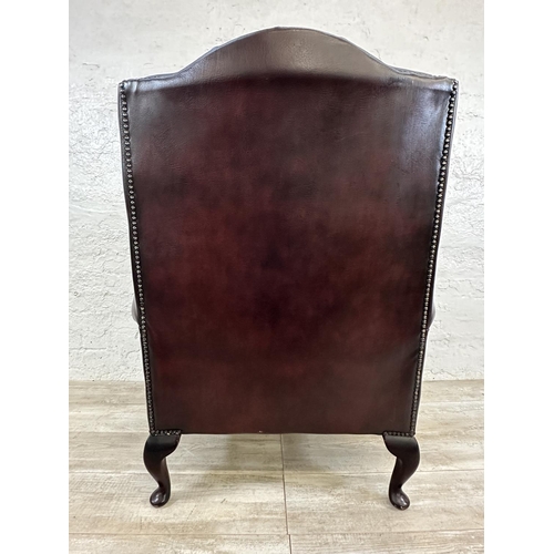 1187 - An oxblood leather Chesterfield wingback armchair - approx. 104cm high x 80cm wide x 75cm deep