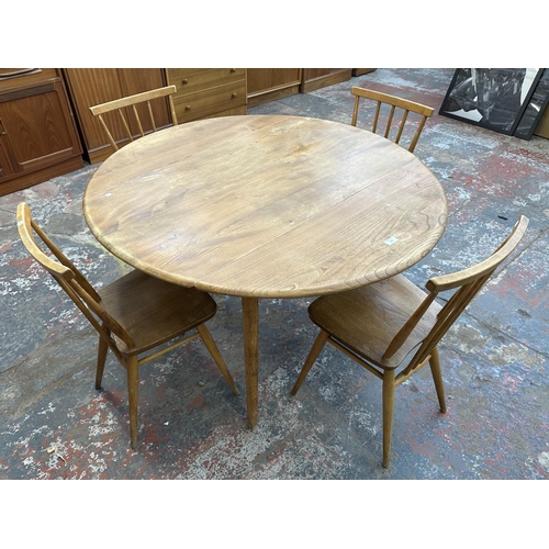 1200 - A mid 20th century Ercol model 384 blonde elm and beech Windsor drop leaf dining table and four mode... 