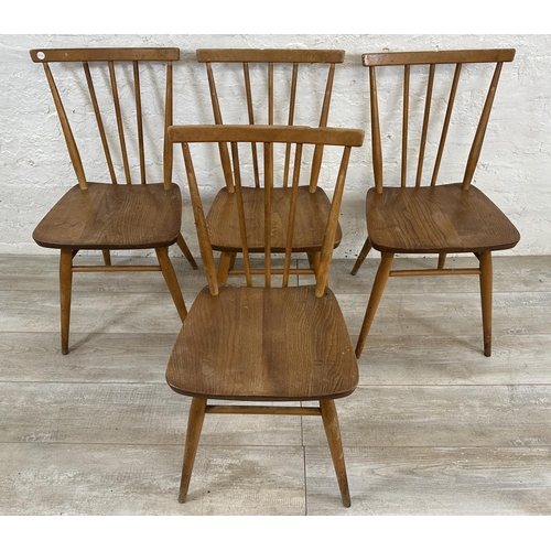 1200 - A mid 20th century Ercol model 384 blonde elm and beech Windsor drop leaf dining table and four mode... 