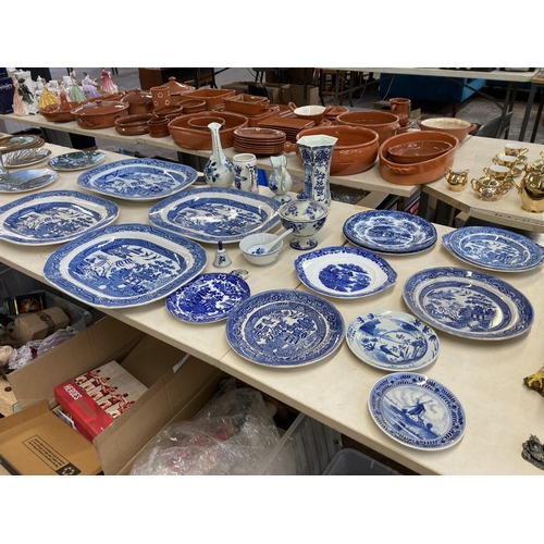 404 - Twenty three pieces of blue and white ceramics to include four Willow pattern meat plates, Delftware... 