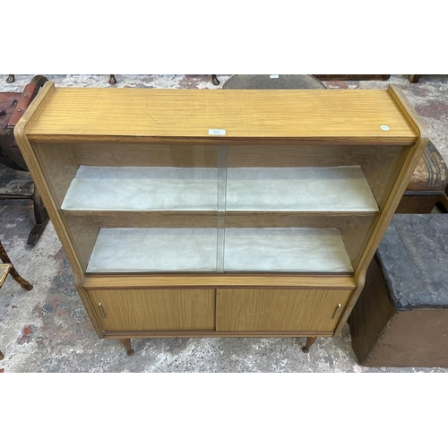 67 - A mid 20th century teak effect bookcase with two glass sliding doors - approx. 109cm high x 91cm wid... 